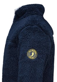 Marineblaue Fleecejacke mit weichem, strukturiertem Finish. Mit einem runden Logopatch in Gelb auf dem oberen Arm. Hoher Kragen.