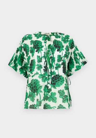 Short-sleeve blouse with a green and black leaf pattern on a light background. Features a round neckline and drawstring details at the waist.