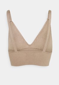 Beżowy, prążkowany top braletowy z głębokim dekoltem w kształcie litery V i cienkimi regulowanymi ramiączkami, bezszwowa taśma pod biustem dla lekkiego wsparcia.