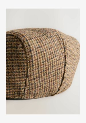 Villane müts, millel on pruuni ja beeži värvi houndstooth muster, ümar kuju ja tekstureeritud pind. Nähtavat riistvara või aktsente ei ole.