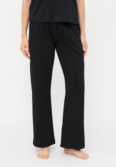 Pantalons noirs amples en tissu doux, au design à jambes larges ; présentent un subtil détail de surpiqûre sur le côté et une taille élastique.