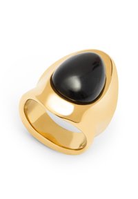 Anillo en tono dorado que presenta una piedra negra pulida en forma de lágrima. Superficie lisa con una banda ancha y un diseño elegante y moderno.