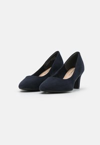 Zapatos de tacón alto de ante azul marino con punta afilada y un acabado elegante y suave. El tacón tiene una altura moderada, de aproximadamente 5-7 cm.