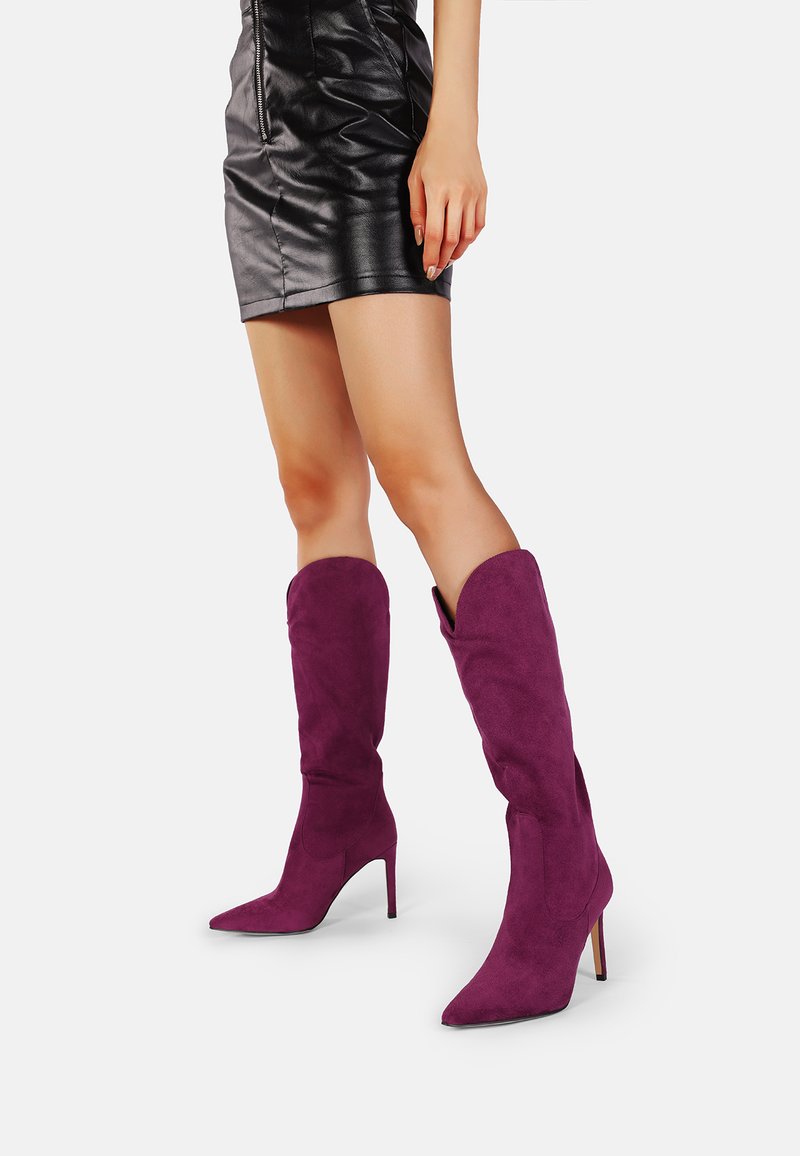 Stivaletti in suede viola fino al ginocchio con punta affusolata e tacco a stiletto, caratterizzati da una texture liscia e un design strutturato.