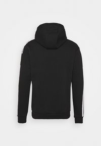 Sweat à capuche noir à manches longues avec des bandes blanches sur le côté extérieur des bras, vu de dos sur un fond uni.