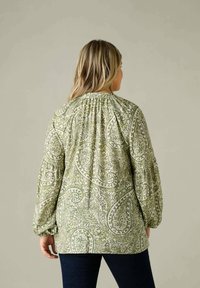 Blusa verde a maniche lunghe con motivo paisley, giogo arricciato e polsini elasticizzati. Realizzata in tessuto leggero con un design fluido.