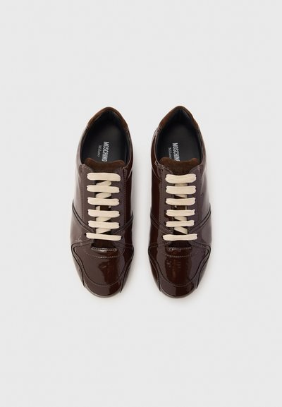 Bruna lacklädersneakers med beige snörning, med rund tå, mjuka bruna mockadetaljer och kontrasterande sömmar.