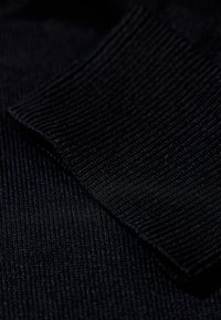 Tessuto a costine blu navy scuro con una texture liscia e una leggera lucentezza, caratterizzato da una vista ravvicinata di sezioni sovrapposte.