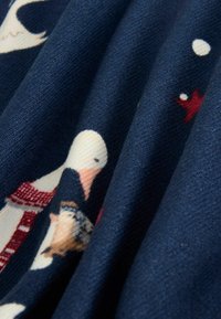 Navy fabric with a textured finish featuring a pattern of skiers, stars, and snowballs in red and white against a dark background.