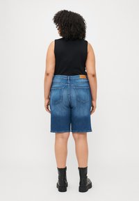 Középkék árnyalatú farmer rövidnadrág, elhalványult hatással, klasszikus öt zsebes dizájnnal és bőr folttal a hátsó derékrészen.