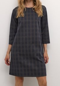 Abito a quadri blu navy con maniche a tre quarti, caratterizzato da linee marroni e grigie. Realizzato in un tessuto morbido con una vestibilità comoda.