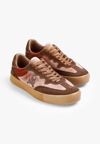 Bruine en roze suède sneakers met een gestructureerde gumzool, voorzien van een schedelafbeelding aan de zijkant, traditionele veters en een gevoerde kraag.