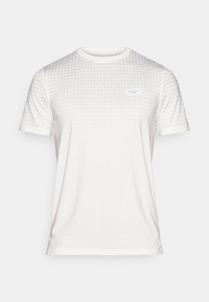 T-shirt branca de mangas curtas com textura padrão. Apresenta um discreto design de bolinhas e um pequeno rótulo na parte frontal. Tecido suave, corte regular.