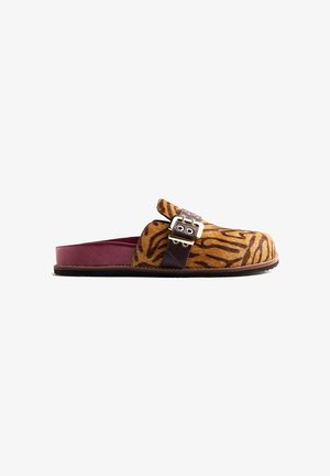 Sabot à enfiler avec motif rayé tigre, bride en cuir noir, et semelle ouverte bordeaux sur fond blanc.