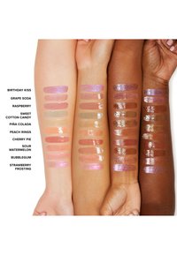 Quatre bras présentant des échantillons de produits à lèvres dans des couleurs et finitions variées, y compris des gloss et des paillettes, disposés en rangées.