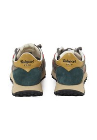 Zapatillas con un diseño de múltiples materiales que presentan acentos de ante en gris, teal y amarillo. Suelas de goma beige y patrones de tracción texturizados en negro.