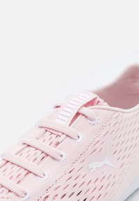 Light pink Puma sneaker with mesh ventilation, matching pink laces, and white Puma logo on the side.