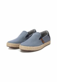 Zapatos de lona azul tipo slip-on con paneles laterales elásticos, suela de yute beige y forro de tela a rayas. Presenta un detalle en cuero marrón.