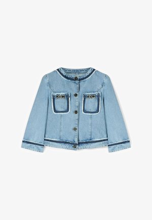 Veste en denim bleu clair avec col rond, boutonnage sur le devant, deux poches poitrine ornées de détails en chaîne métallique, et bords effilochés aux poches et aux poignets.