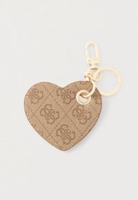 Hnědý klíčenka ve tvaru srdce z kůže s raženým vzorem, zlatým kováním a připevňovacím klipem, vybavený kroužkem na klíče.