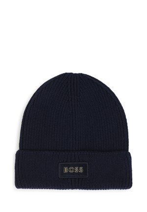 Bonnet tricoté bleu foncé avec revers plié comportant un patch rectangulaire cousu portant l’inscription "BOSS" en lettres dorées.