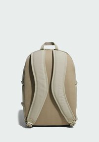 Mochila beige con panel trasero de malla acolchada y correas ajustables. Cuenta con un asa superior y bolsillos laterales, con una forma rectangular estructurada.