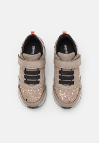 Sapatos de couro castanho com atacadores pretos e uma fita de velcro, com specks metálicos nos lados e um colarinho almofadado para conforto.