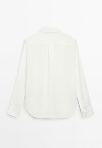 White long-sleeve shirt with a collar, smooth texture, straight cut, and buttoned cuffs. Features a back yoke and central pleat.