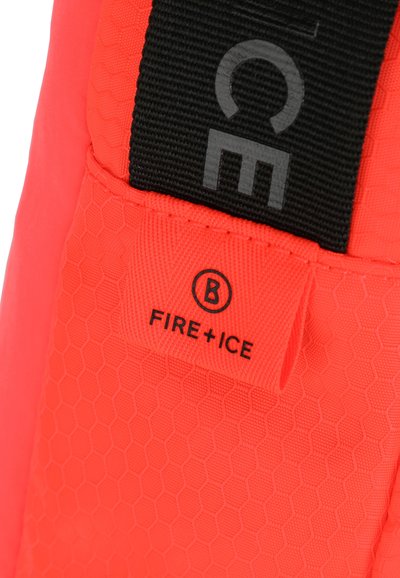 Tessuto a pattern esagonale arancione con una tracolla nera. Presenta un'etichetta con scritto "FIRE + ICE" e un logo circolare con la lettera "B".