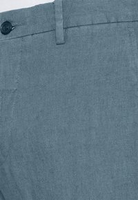 Blaue Leinenhose aus einem strukturierten, atmungsaktiven Stoff mit Knopfverschluss und einem angenehmen Bunddesign.