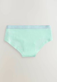 Svetlo turkizno spodnje perilo z svetlo modrim pasom, na katerem je ponavljajoč se napis "next", položeno na nevtralno ozadje.