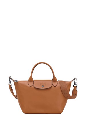 Tan leather handbag with a rounded shape, dual top handles, and a detachable strap. Features a front snap closure and subtle logo detail.