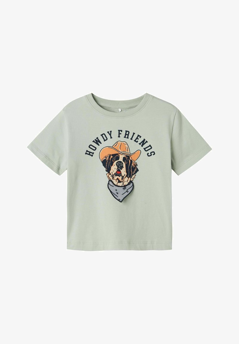 Šviesiai žalias medvilninis marškinėlis su šuns, dėvinčio kaubojaus skrybėlę ir šalį, grafika, o virš dizaino yra tekstas "HELLO FRIENDS".