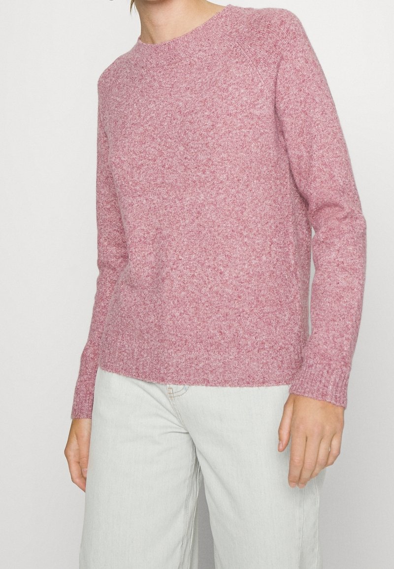 Rosa gestrickter Pullover mit rundem Ausschnitt, gerippten Bündchen und Saum, weiche Textur, figurbetonter Stil, lange Ärmel, gefertigt aus warmem, flauschigem Material.