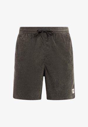 Shorts en velours côtelé gris foncé avec taille élastique et cordon de serrage noir, avec une petite écusson logo blanc près de l'ourlet sur la jambe droite.