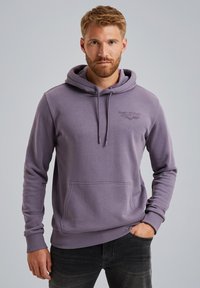 Paarse hoodie gemaakt van zacht materiaal. Beschikt over een frontale kangoeroezak en ribgebreide manchetten. Logo in reliëf op de borst.