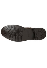 Semelle de chaussure en cuir marron avec des motifs de texture antidérapants, comprenant des rainures circulaires et horizontales ; présente des accents en relief pour une meilleure traction.