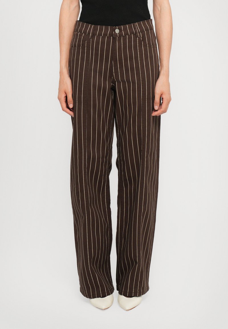Brown striped wide-leg pants made of soft fabric, featuring vertical cream stripes, front pockets, and a button closure at the waist.