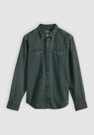 Dark blue denim shirt with long sleeves, snap-button closure, Western-style yoke, and two chest pockets. Features contrast stitching and a solid texture.