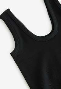 Top in maglia nera a coste con spalline larghe e scollatura arrotondata. La texture è liscia e elasticizzata, progettata per comfort e vestibilità.