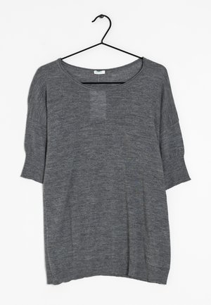 Maglione grigio a maniche corte in maglia con scollo arrotondato appeso a una gruccia nera in metallo su sfondo bianco.