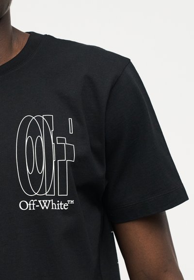 Μαύρο κοντομάνικο μπλουζάκι με το λευκό περίγραμμα του γράμματος "Off" και το κείμενο "Off-White™" στο αριστερό στήθος, φορεμένο από άτομο με σκούρο δέρμα.
