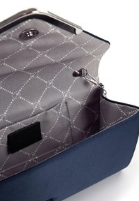 Nachtblauen Clutch mit glatter Oberfläche, silbernen Beschlägen und einem grauen, gemusterten Innenfutter mit geometrischem Design. Verfügt über ein Innenfach.