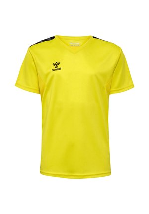 To børn iført gule hummel sportstrøjer og matchende shorts, står mod en ensfarvet lys baggrund.