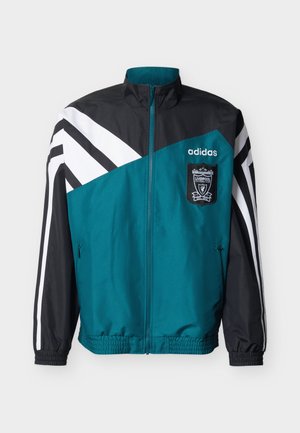 Turkoosi-musta Adidas:n vetoketjullinen verkkatakki valkoisilla raidoilla, Liverpoolin jalkapalloseuran vaakunalla, vetoketjulla edessä sekä joustavilla hihansuu- ja helmaresoreilla.