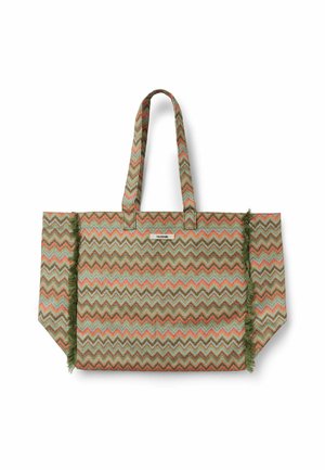 Große Tote-Tasche mit mehrfarbigem Zickzackmuster in Erdtönen, grünen Fransen an den Seiten und zwei langen Henkeln.