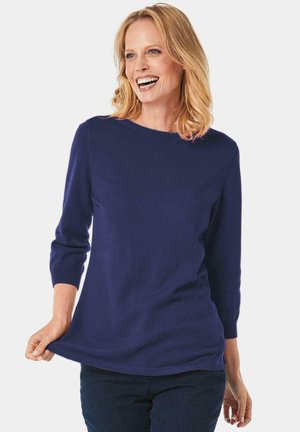 Navyblauer gestrickter Pullover, Bootsausschnitt, Dreiviertelärmel, gerippter Saum, weiche Textur, kombiniert mit dunklen Jeans, lässiger Schnitt.