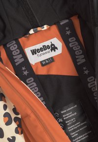 Vattentåligt ytterkläder med en orange innervaddering, svarta detaljer och ett leopardmönster. Inkluderar skötsel- och storleksetiketter.