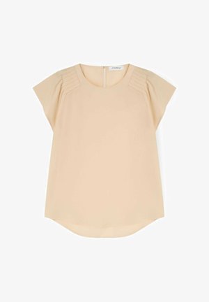 Blouse beige à manches courtes avec encolure ronde, épaules plissées et fermeture éclair au dos.