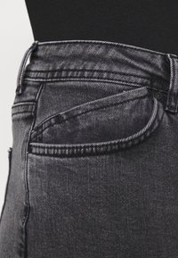 Svarta denimjeans med en smal passform, med en klassisk femfickdesign, kontrasterande sömnad och en krökt frontfickdetalj.